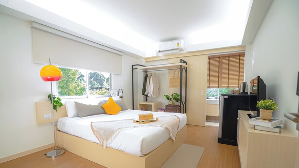 A modern bedroom with a bed, bedside tables, a desk, and a window. - House Hotel North Pattaya (Pattaya)