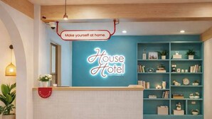 A reception area with a neon sign reading "House Hotel" and a sign above it stating "Make yourself at home." - House Hotel North Pattaya (Pattaya)