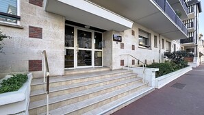 Un edificio con fachada de piedra y una escalera que conduce a la entrada, con un letrero que dice "ASCOT".