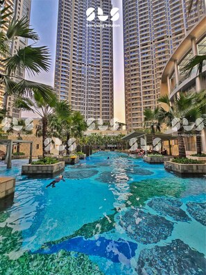 A swimming pool area with high-rise buildings in the background. - Teras By SanLiving - 3BR - Hublife Mall (Jakarta)
