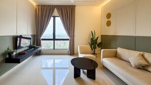 A modern living room with a sofa, a coffee table, a TV, and a large window with curtains.