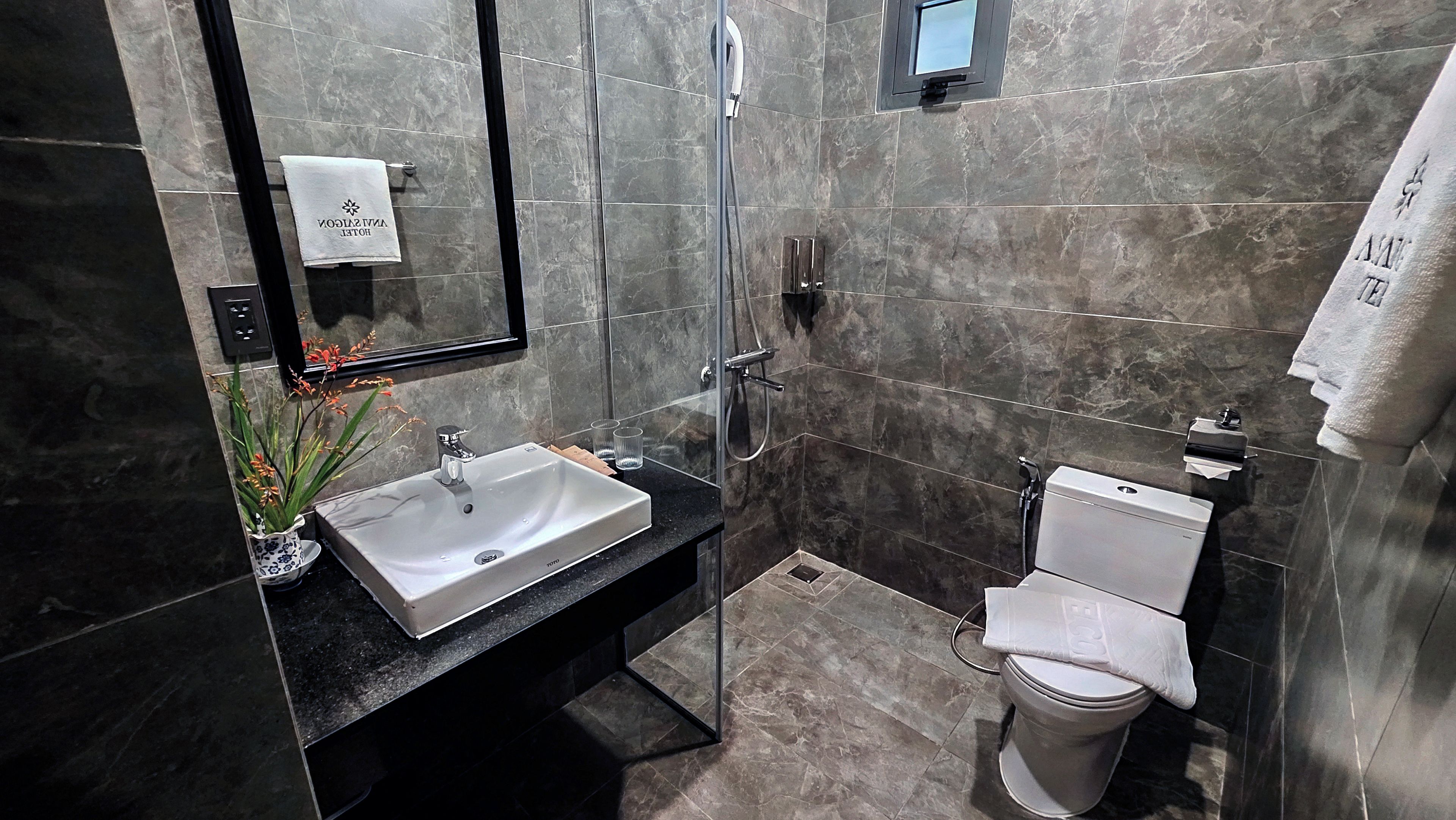 Une salle de bain moderne avec une douche à parois de verre, un lavabo blanc et des toilettes.