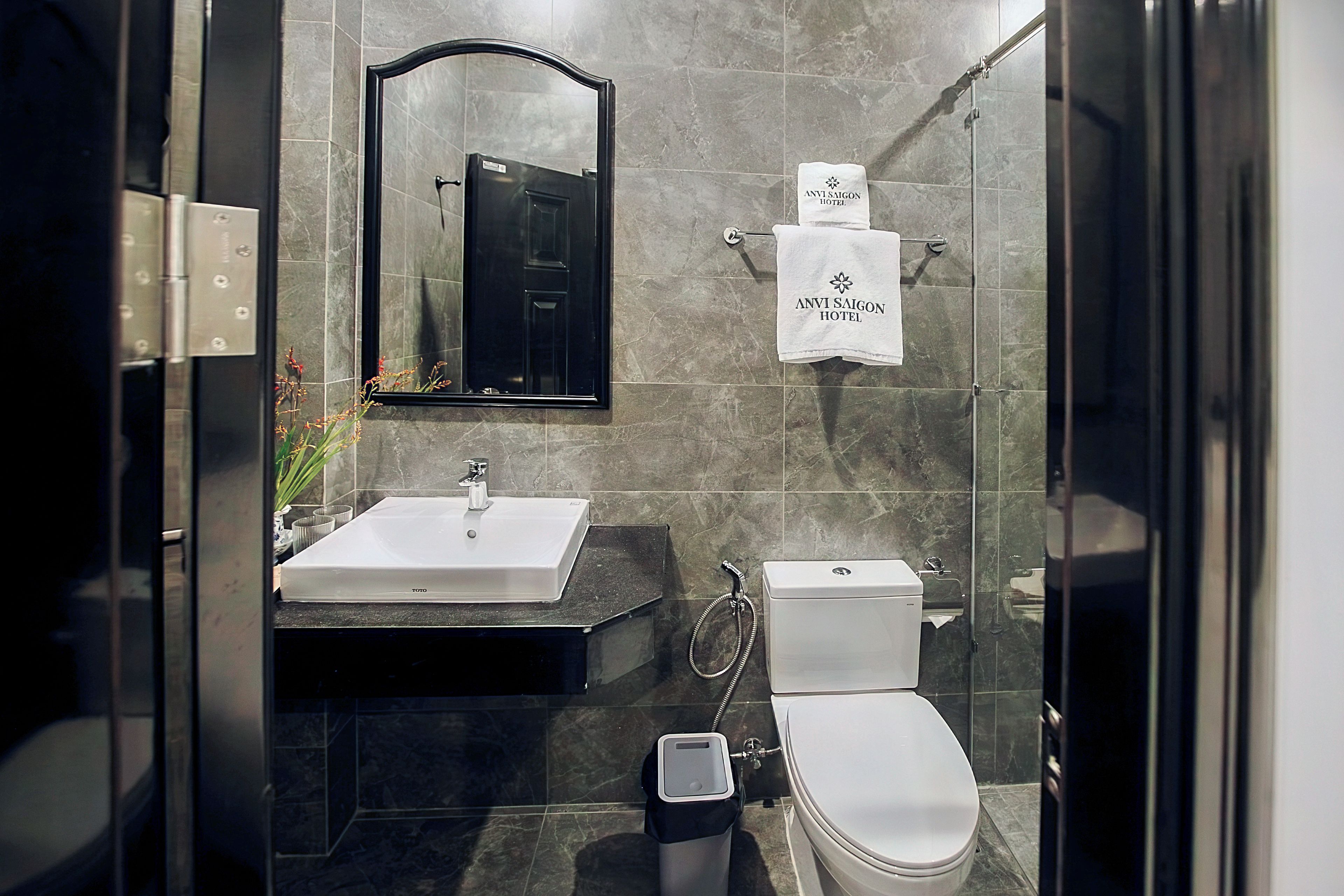 A modern bathroom with a white sink, a toilet, and a glass-enclosed shower area.