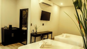 A hotel room with a bed, bedside tables, a desk, a mirror, a TV, and a plant. - Anvi Saigon Boutique Hotel (Ho Chi Minh City)