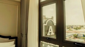 A hotel room with a bed, a large window with curtains, and a balcony with a railing. - Anvi Saigon Boutique Hotel (Ho Chi Minh City)