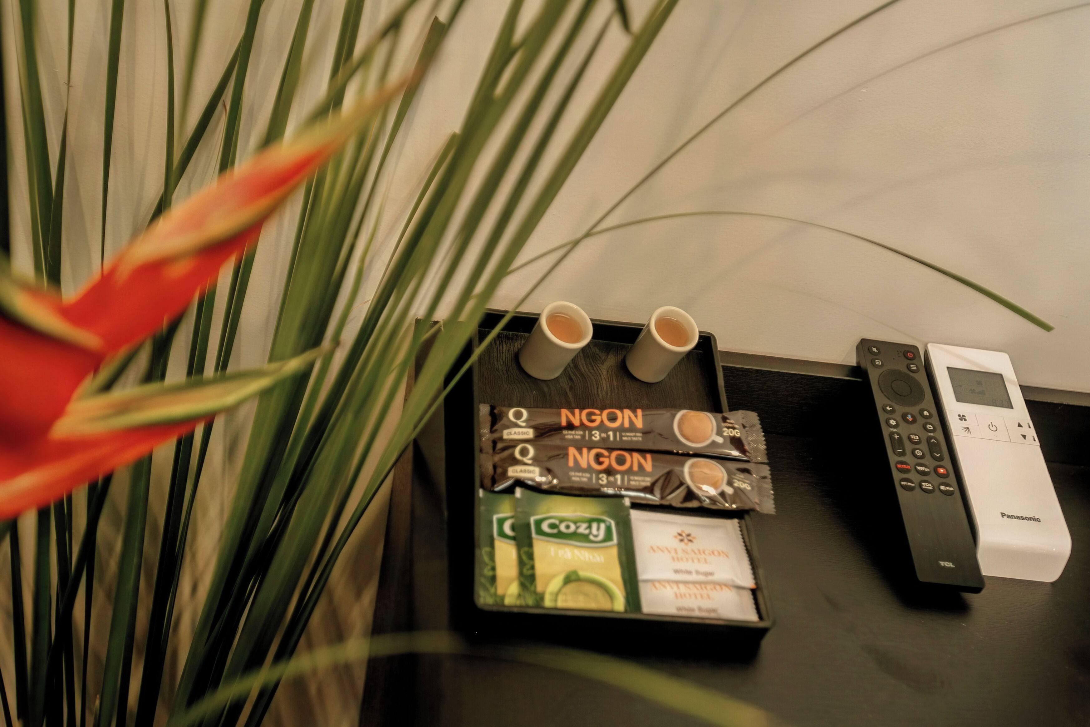 Ein Hotel-Rezeptionsbereich mit einem schwarzen Empfangstresen, einem Panasonic-Telefon und einer Kaffeemaschine.