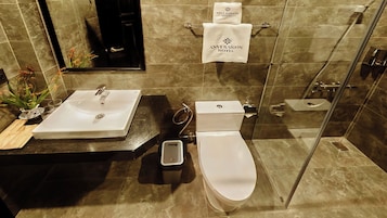 A modern bathroom with a sink, toilet, and shower.