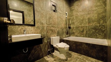 A bathroom with a sink, toilet, and bathtub.