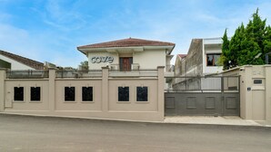 Propiedad residencial privada con portón, placa identificadora y un estilo arquitectónico moderno.