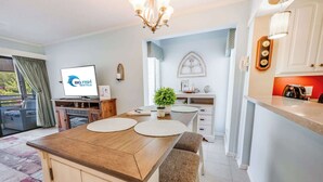 Una cocina moderna con comedor, televisión y vistas al exterior.