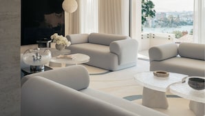 Un salon moderne avec un grand canapé, deux tables basses et un téléviseur.