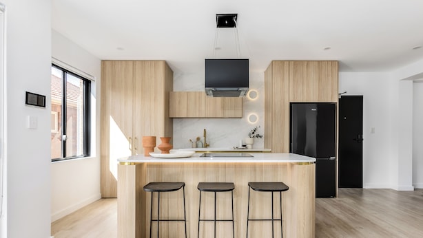 A modern kitchen with a central island, wooden cabinets, and a black refrigerator. - Medusa Bondi (Bondi)