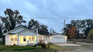A two-story house with a garage, a front yard, and a road in the foreground.