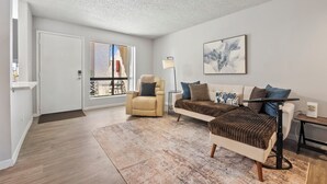Ein modernes Wohnzimmer mit Sofa, Sessel und Couchtisch.