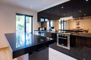 Una cocina moderna con armarios oscuros, una isla central y una estufa a gas.