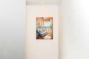 Ein Zimmer mit einer Holterrasse, einer Couch und Blick auf den Ozean.