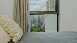 A hotel room with a bed, a window with a view of city buildings, and a curtain. - 5 Min to Crown & NGV | Stylish 2BR | City View (Southbank)
