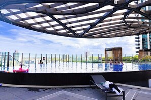 A rooftop infinity pool with a modern canopy, surrounded by a high-rise urban landscape. - Southbank 3BR 2Bath | Free Parking & City Views (Southbank)
