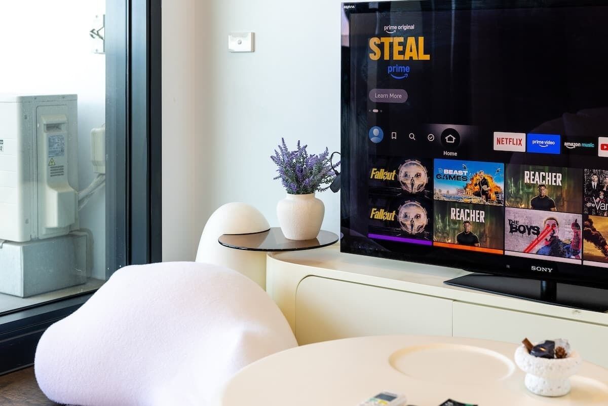 A modern living room with a flat-screen TV displaying a streaming service interface.