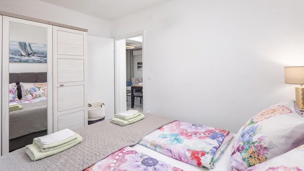 A hotel room with a bed, a wardrobe, a bathroom, and a view of the sea. - Susi's Holiday Home (Medulin)