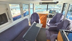 Schiffsausstattung mit Sofa, Sesseln, Tisch und Armaturenbrett.