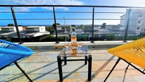 Un balcón con una mesa, dos sillas y una botella de agua.
