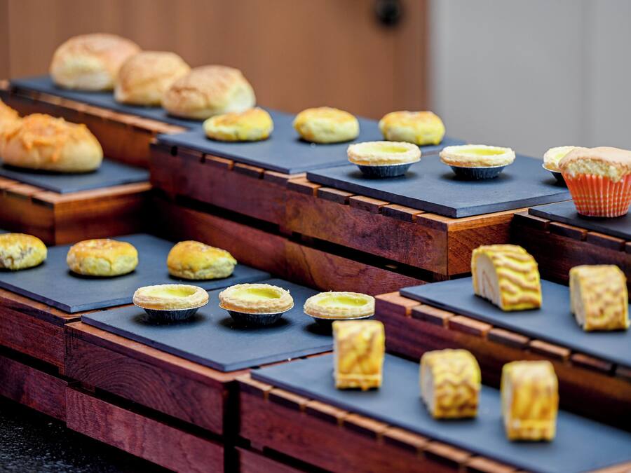A variety of pastries displayed on wooden stands.