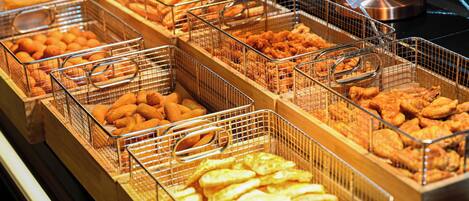 Un bufé con diversos alimentos fritos en cestas de alambre.