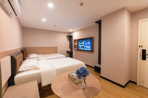 A hotel room with two beds, a round table with a vase of flowers, a mounted TV, and a wardrobe. - YueZhi Hotel Guangzhou East Station (Guangzhou)