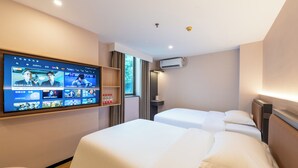 A hotel room with two beds, a TV mounted on the wall displaying various channels, an air conditioning unit, and a window with curtains. - YueZhi Hotel Guangzhou East Station (Guangzhou)