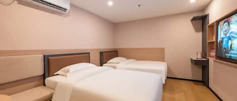 Habitación de hotel con dos camas, un banco, aire acondicionado, televisor y un estante con un control remoto.