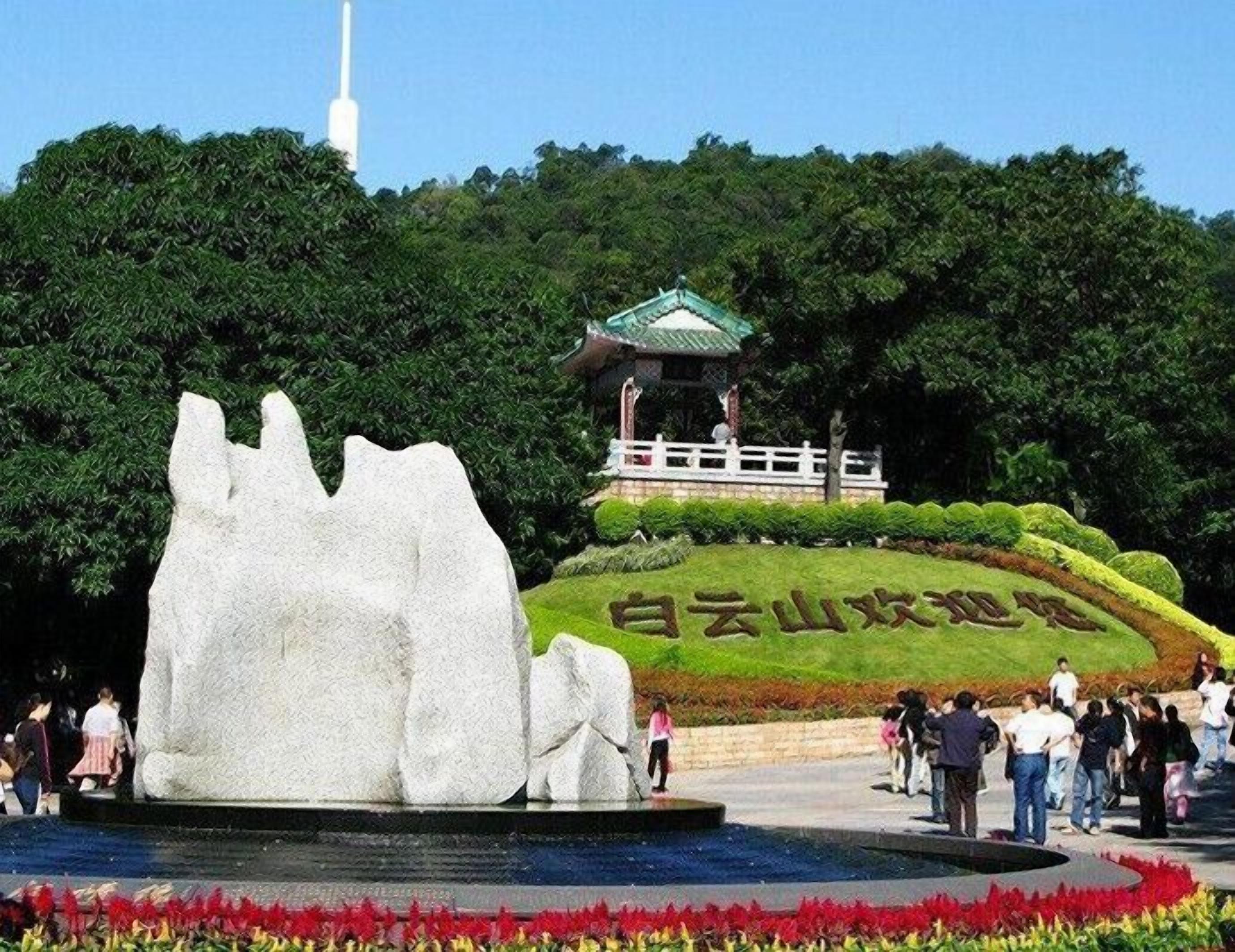A large rock sculpture, a pagoda, and a sign with Chinese characters.