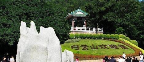A large rock sculpture, a pagoda, and a sign with Chinese characters.