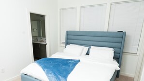 A bedroom with a bed, a ceiling fan, and a window with blinds. - Happiness at NO-CHARGE in walkaway Akard Travelbae Luxe Haus (Dallas)
