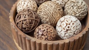 A wooden bowl containing various textured spheres. - Happiness at NO-CHARGE in walkaway Akard Travelbae Luxe Haus (Dallas)