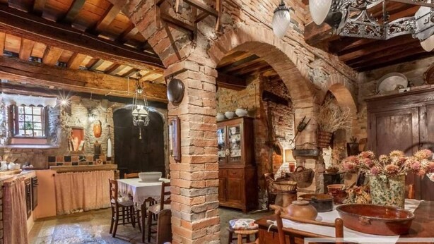 A rustic interior with exposed brick walls, wooden beams, and traditional furnishings. - PALAZZO PALESA B&B dimora storica (San Casciano dei Bagni)