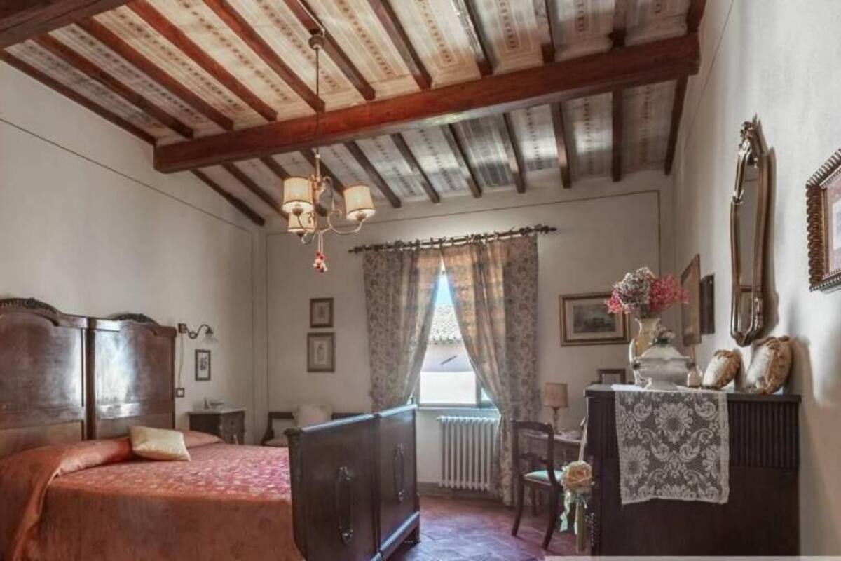 Ein traditionell eingerichteter Raum mit einem hölzernen Bett, einem Schminktisch, einem Spiegel und einer Kandelaber.