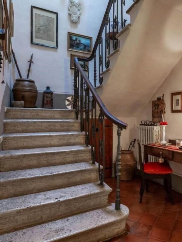 A staircase with a wooden handrail and a radiator on the landing. - PALAZZO PALESA B&B dimora storica (San Casciano dei Bagni)