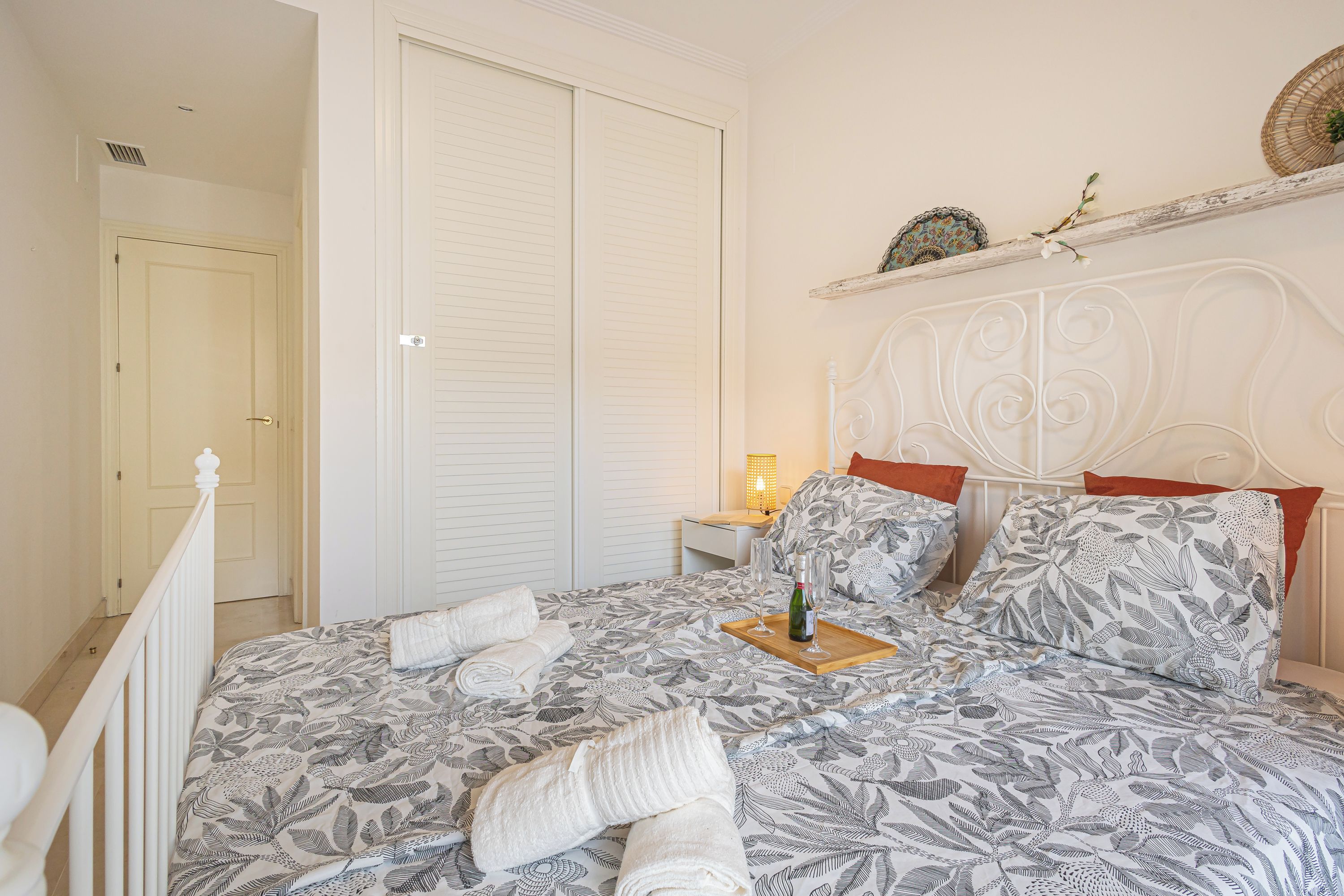 A bedroom with a bed, pillows, a bedside table, and a nightstand.