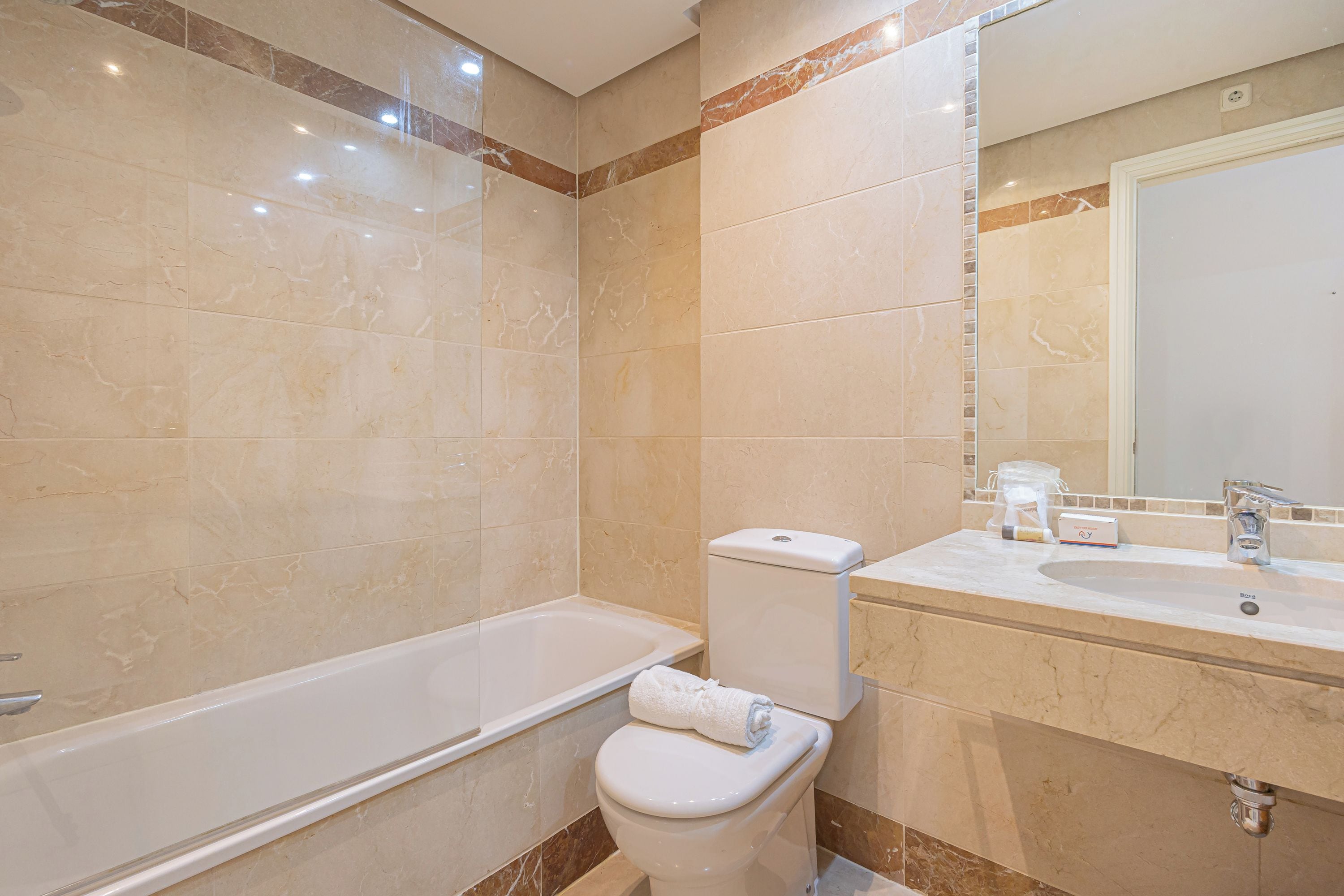 A bathroom with a bathtub, toilet, and sink.