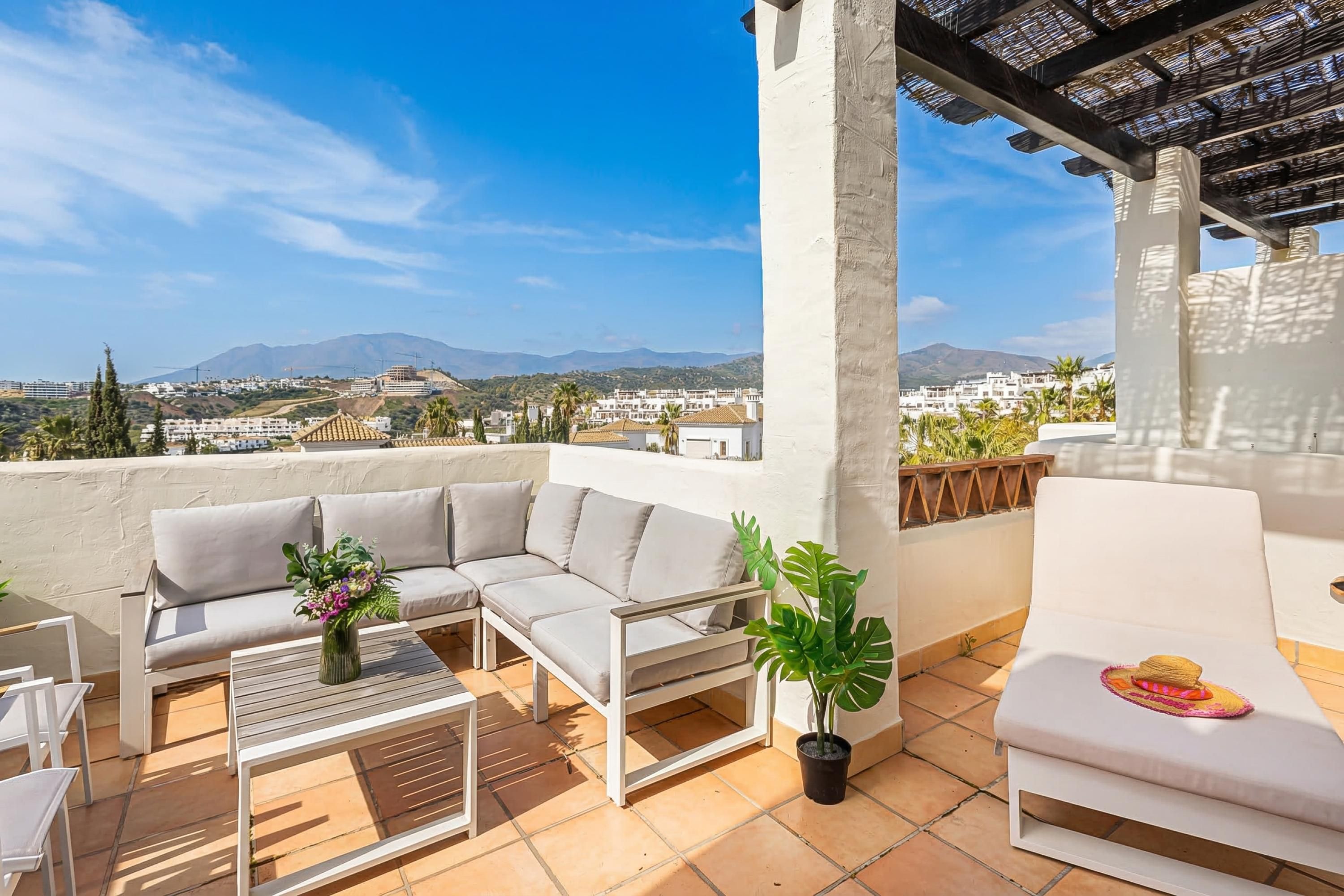Une terrasse sur le toit avec un canapé, une table et un fauteuil de relaxation.