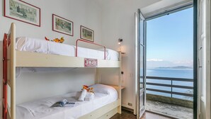 A bunk bed with a view of the sea through an open door. - Villa Incanto Sul Lago: Lakefront, Garden & Balconies (Laveno Mombello)