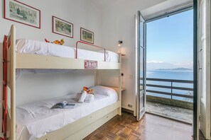 A bunk bed with a view of the sea through an open door. - Villa Incanto Sul Lago: Lakefront, Garden & Balconies (Laveno Mombello)