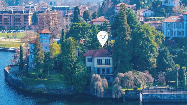 A waterfront property with a tower, surrounded by trees and a body of water. - Villa Incanto Sul Lago: Lakefront, Garden & Balconies (Laveno Mombello)