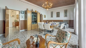 A spacious living area with a dining table, chairs, a sofa, and a chandelier. - Villa Incanto Sul Lago: Lakefront, Garden & Balconies (Laveno Mombello)
