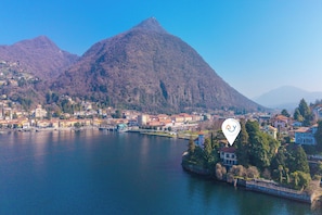 Ein See mit einem Berg im Hintergrund und einer Stadt mit Gebäuden entlang des Ufers.