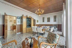 A spacious living area with a dining table, chairs, a sofa, and a chandelier. - Villa Incanto Sul Lago: Lakefront, Garden & Balconies (Laveno Mombello)