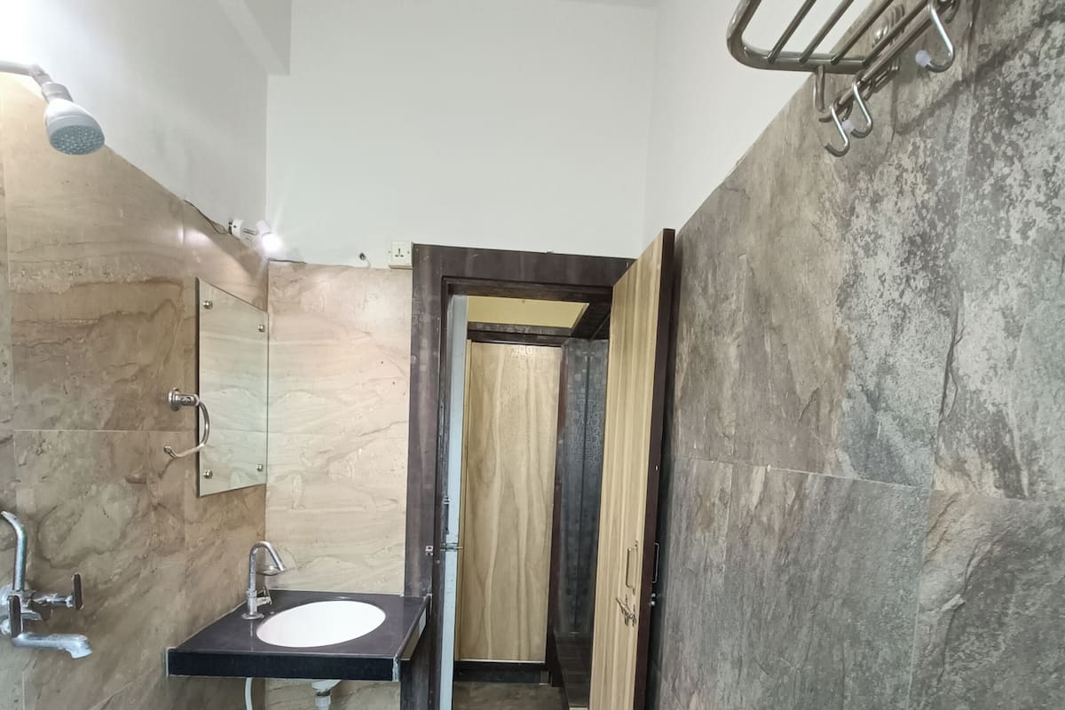 Une salle de bain équipée d’un lavabo, d’un miroir, d’une douche et d’un porte-serviettes.