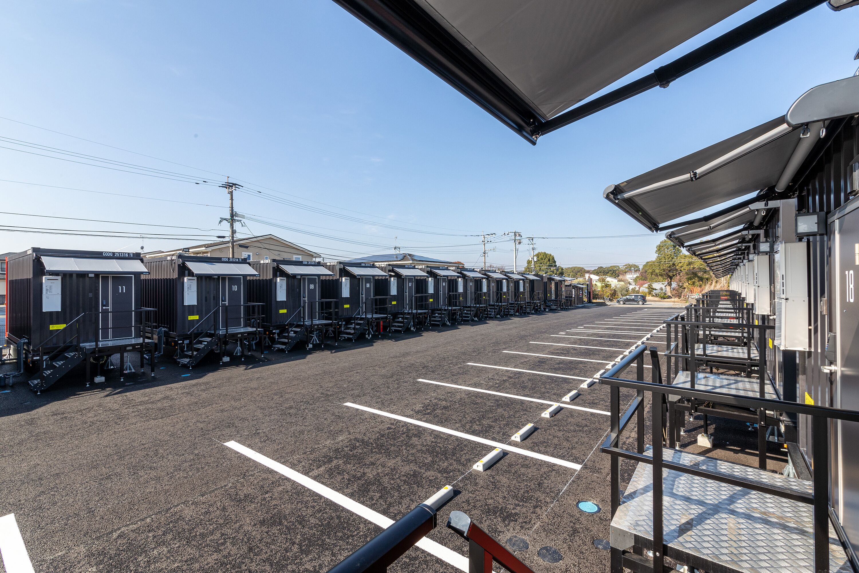 A parking lot with rows of trailers, each with a small set of stairs leading up to the entrance.