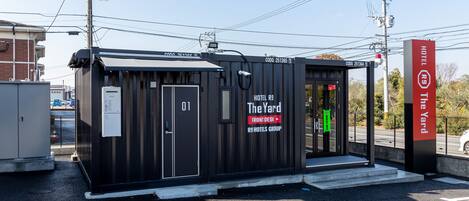 Il s’agit d’un hôtel de taille modeste, doté d’une réception et baptisé « The Yard » par le groupe R9 Hotels. Il se distingue par son entrée simple et son espace de stationnement bien visible.